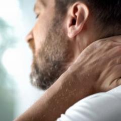 man holding his neck 