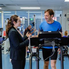man walking on treadmill in rehabilitation clinic speaking with dr elise gane